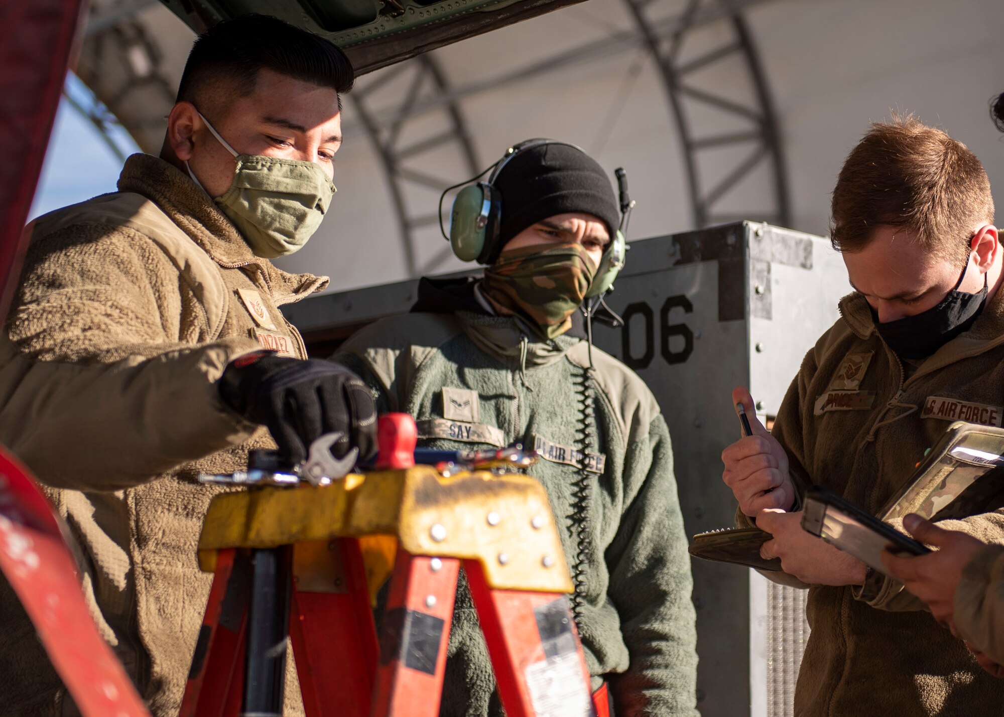 Tech. Sgt. Jorge Gonzalez (left) and Staff Sgt. William Price (right), 4th Fighter Readiness Squadron quality assurance inspectors, perform a personal evaluation on Airman 1st Class Richard Say, 333rd Fighter Squadron avionics technician, at Seymour Johnson Air Force Base, North Carolina, Feb. 4, 2021.