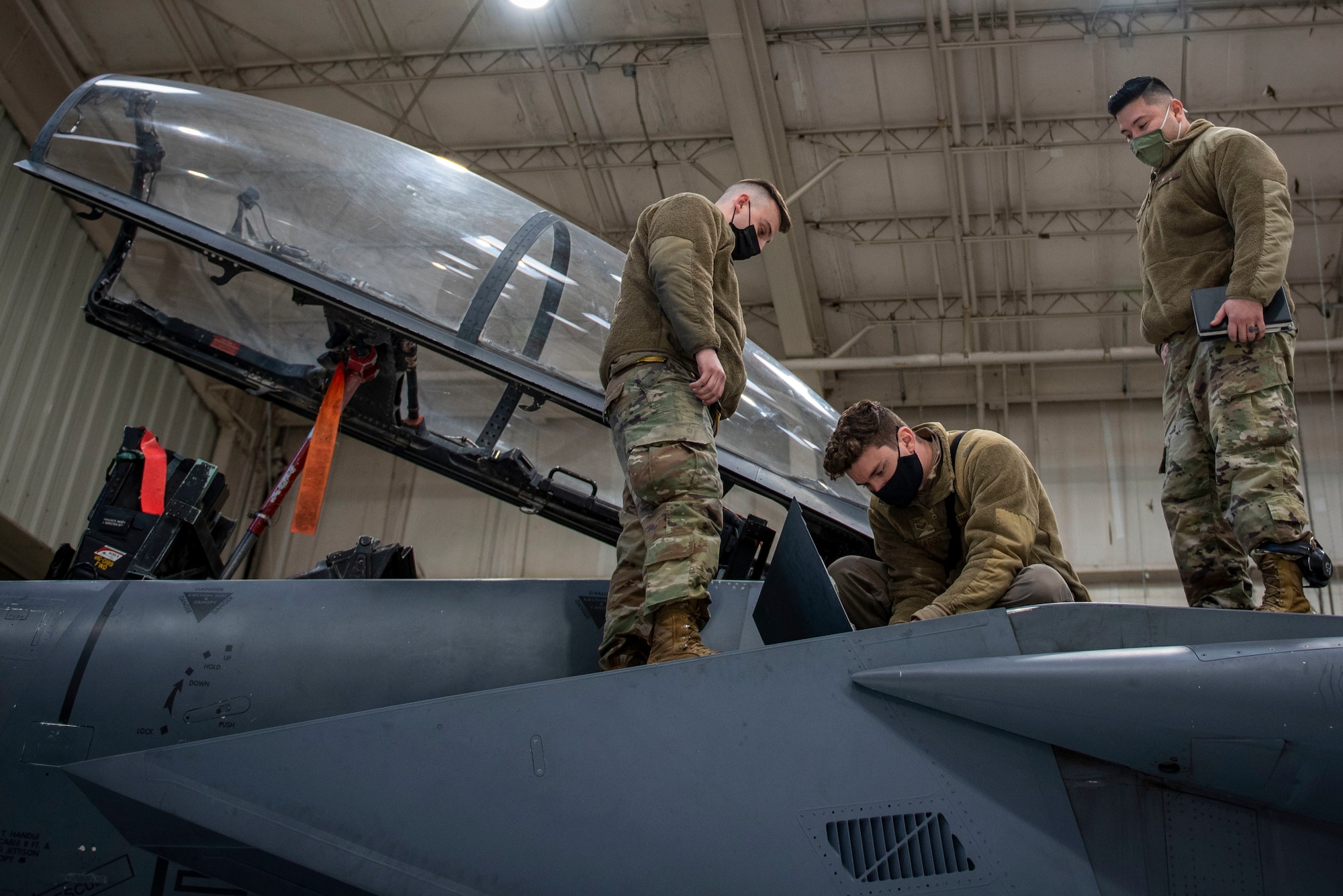Tech. Sgt. Jorge Gonzalez, 4th FRS quality assurance inspector (right), observes maintainers working on an F-15E Strike Eagle at Seymour Johnson Air Force Base, North Carolina, Feb. 4, 2021.