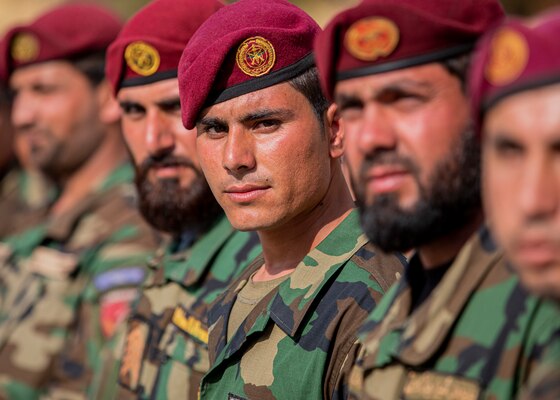 Foreign military service members wearing berets stand in a line.