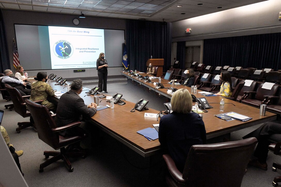 Photo shows a group sitting in a conference room.