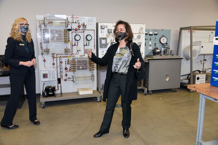 Photo shows two women looking at equipment in training room.