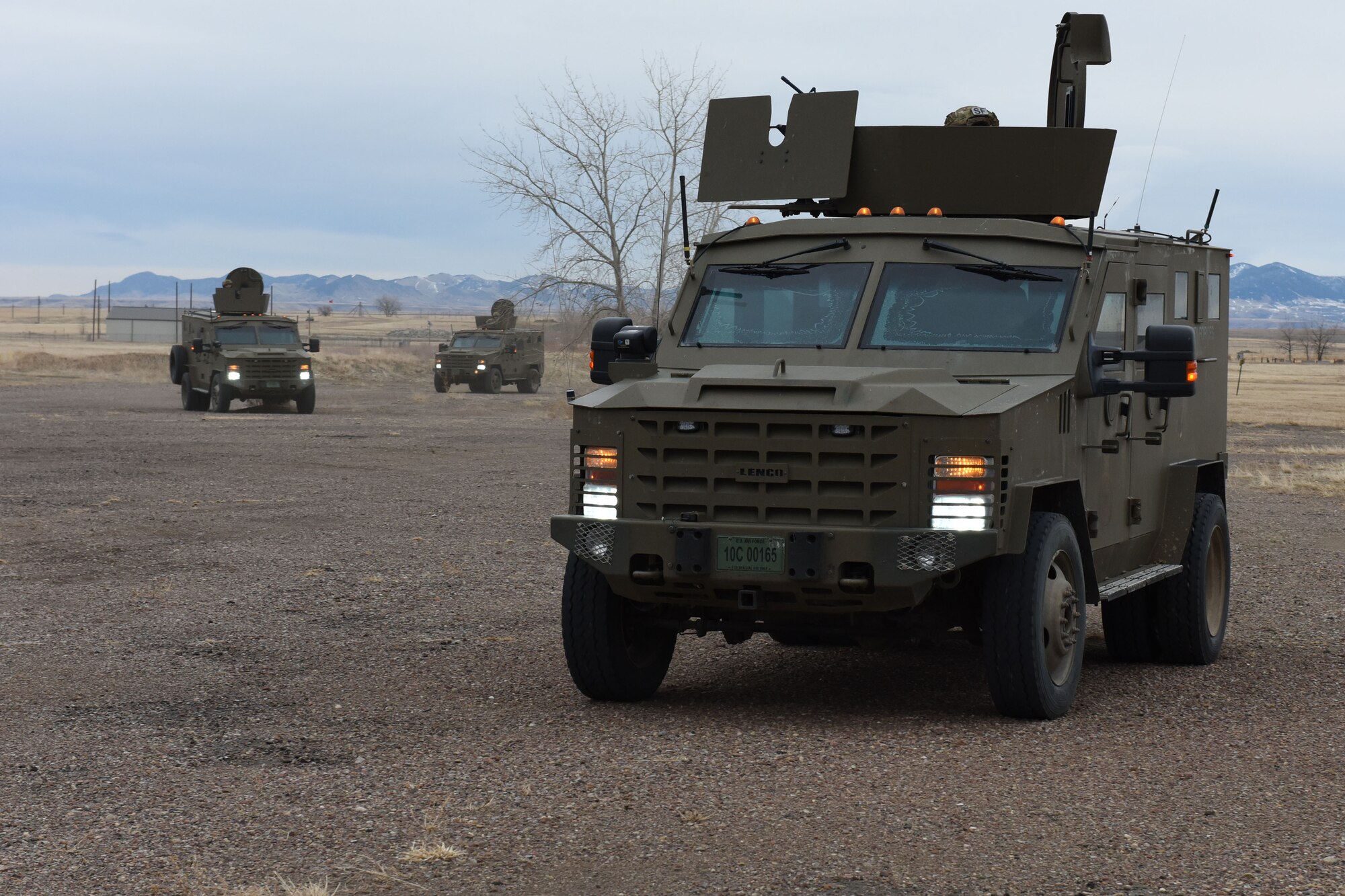 Defends with rifles look into the back of a payload transporter van with the intent of moving into the van and neutralizing the threat.