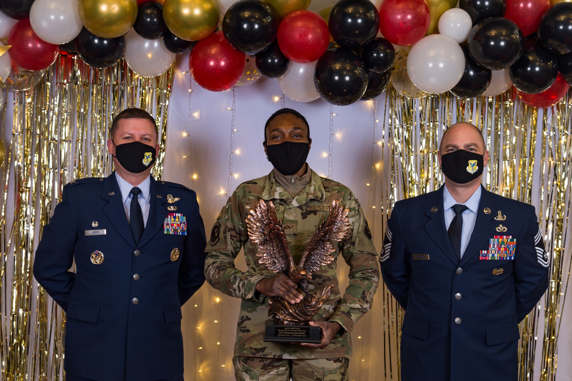 Senior Airman Yasmeen Joachim, 436th Operations Support Squadron, poses for a photo with Col. Matthew Jones, 436th Airlift Wing commander, and Chief Master Sgt. Jeremiah Grisham, 436th AW interim command chief, following the conclusion of the 436th AW 2020 Annual Awards Ceremony at Dover Air Force Base, Delaware, Jan. 28, 2021. Yoachim received the wing's Airman service of the year award and an eagle trophy. (U.S. Air Force photo by Roland Balik)