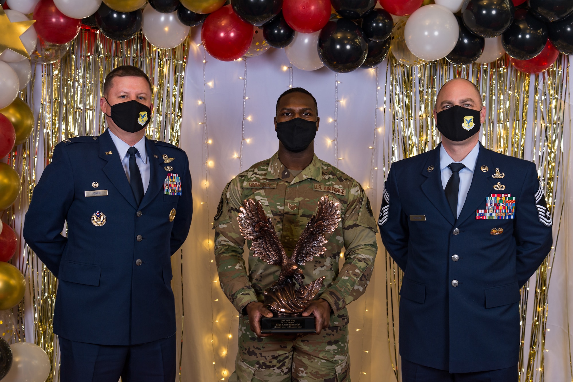 Staff Sgt. Kevin Moncrief, 436th Operations Support Squadron, poses for a photo with Col. Matthew Jones, 436th Airlift Wing commander, and Chief Master Sgt. Jeremiah Grisham, 436th AW interim command chief, following the conclusion of the 436th AW 2020 Annual Awards Ceremony at Dover Air Force Base, Delaware, Jan. 28, 2021. Moncrief was named the wing's noncommissioned officer of the year and received an eagle trophy. (U.S. Air Force photo by Roland Balik)