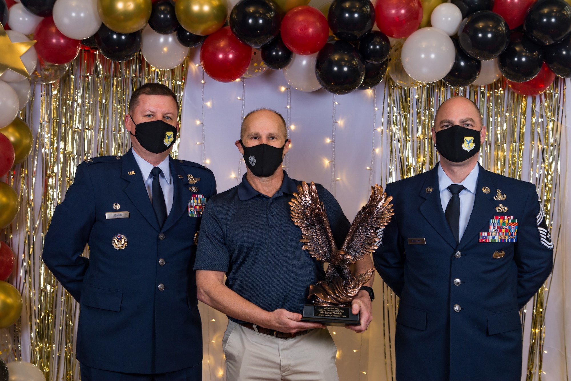 David Sawicki, 436th Operations Support Squadron, poses for a photo with Col. Matthew Jones, 436th Airlift Wing commander, and Chief Master Sgt. Jeremiah Grisham, 436th AW interim command chief, following the conclusion of the 436th AW 2020 Annual Awards Ceremony at Dover Air Force Base, Delaware, Jan. 28, 2021. Sawicki was named the wing's category I civilian of the year and received an eagle trophy. (U.S. Air Force photo by Roland Balik)