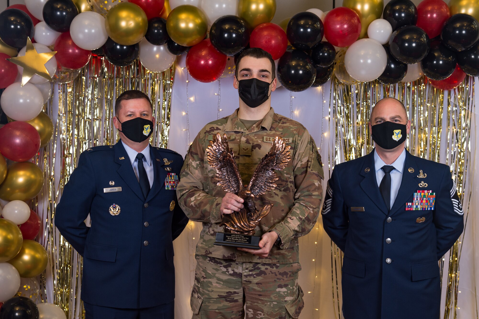 Senior Airman Nicholas Jackson, 436th Communication Squadron, poses for a photo with Col. Matthew Jones, 436th Airlift Wing commander, and Chief Master Sgt. Jeremiah Grisham, 436th AW interim command chief, following the conclusion of the 436th AW 2020 Annual Awards Ceremony at Dover Air Force Base, Delaware, Jan. 28, 2021. Jackson was named the wing's honor guard member of the year winner and received an eagle trophy. (U.S. Air Force photo by Roland Balik)