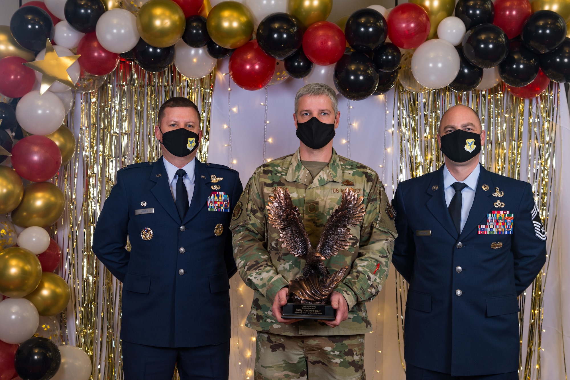 Senior Master Sgt. Andrew Casper, 436th Aircraft Maintenance Squadron, poses for a photo with Col. Matthew Jones, 436th Airlift Wing commander, and Chief Master Sgt. Jeremiah Grisham, 436th AW interim command chief, following the conclusion of the 436th AW 2020 Annual Awards Ceremony at Dover Air Force Base, Delaware, Jan. 28, 2021. Casper was named the wing's senior noncommissioned officer of the year and received an eagle trophy. (U.S. Air Force photo by Roland Balik)