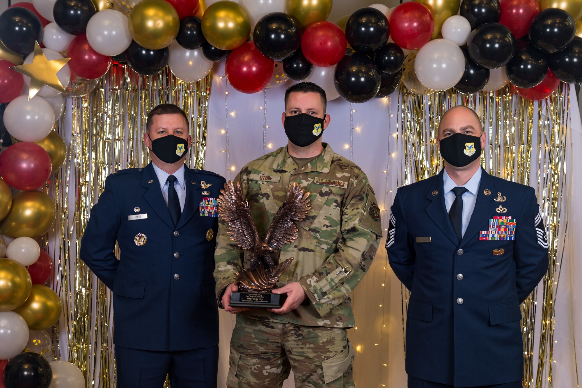 Master Sgt. Tony Otis, 436th Wing Staff Agencies, poses for a photo with Col. Matthew Jones, 436th Airlift Wing commander, and Chief Master Sgt. Jeremiah Grisham, 436th AW interim command chief, following the conclusion of the 436th AW 2020 Annual Awards Ceremony at Dover Air Force Base, Delaware, Jan. 28, 2021. Otis was named the wing's first sergeant of the year and received an eagle trophy. (U.S. Air Force photo by Roland Balik)