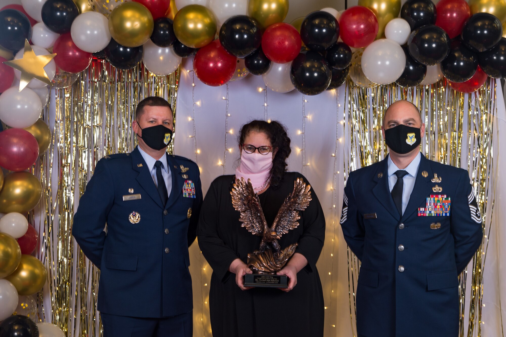 Carmel-Ann Feliciani, 436th Wing Staff Agencies, poses for a photo with Col. Matthew Jones, 436th Airlift Wing commander, and Chief Master Sgt. Jeremiah Grisham, 436th AW interim command chief, following the conclusion of the 436th AW 2020 Annual Awards Ceremony at Dover Air Force Base, Delaware, Jan. 28, 2021. Feliciani was named the wing's category III civilian of the year and received an eagle trophy. (U.S. Air Force photo by Roland Balik)