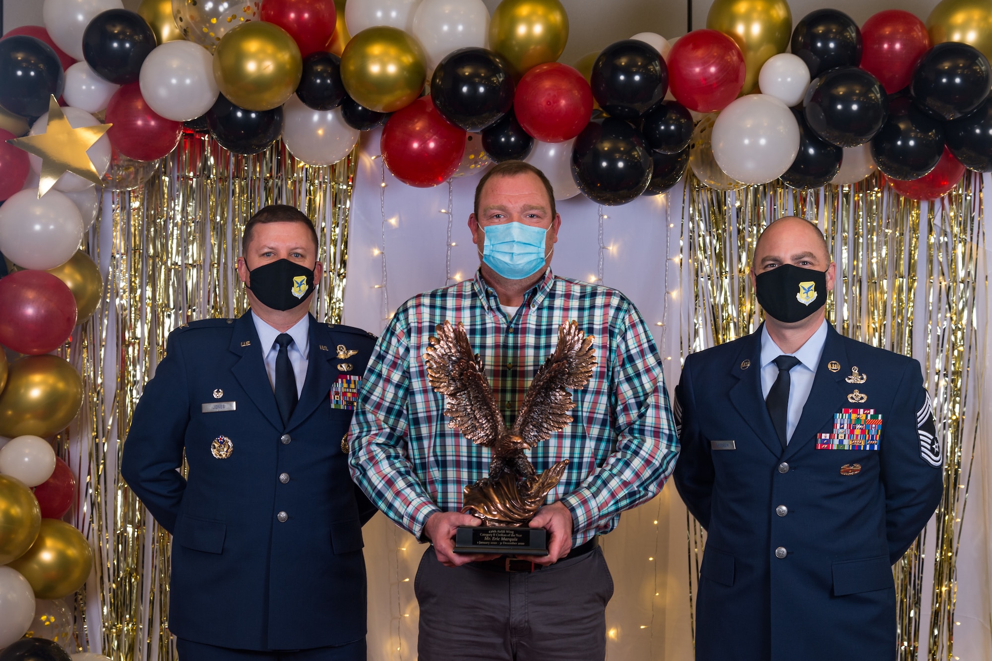 Eric Marquis, 436th Medical Support Squadron, poses for a photo with Col. Matthew Jones, 436th Airlift Wing commander, and Chief Master Sgt. Jeremiah Grisham, 436th AW interim command chief, following the conclusion of the 436th AW 2020 Annual Awards Ceremony at Dover Air Force Base, Delaware, Jan. 28, 2021. Marquis was named the wing's category II civilian of the year and received an eagle trophy. (U.S. Air Force photo by Roland Balik)