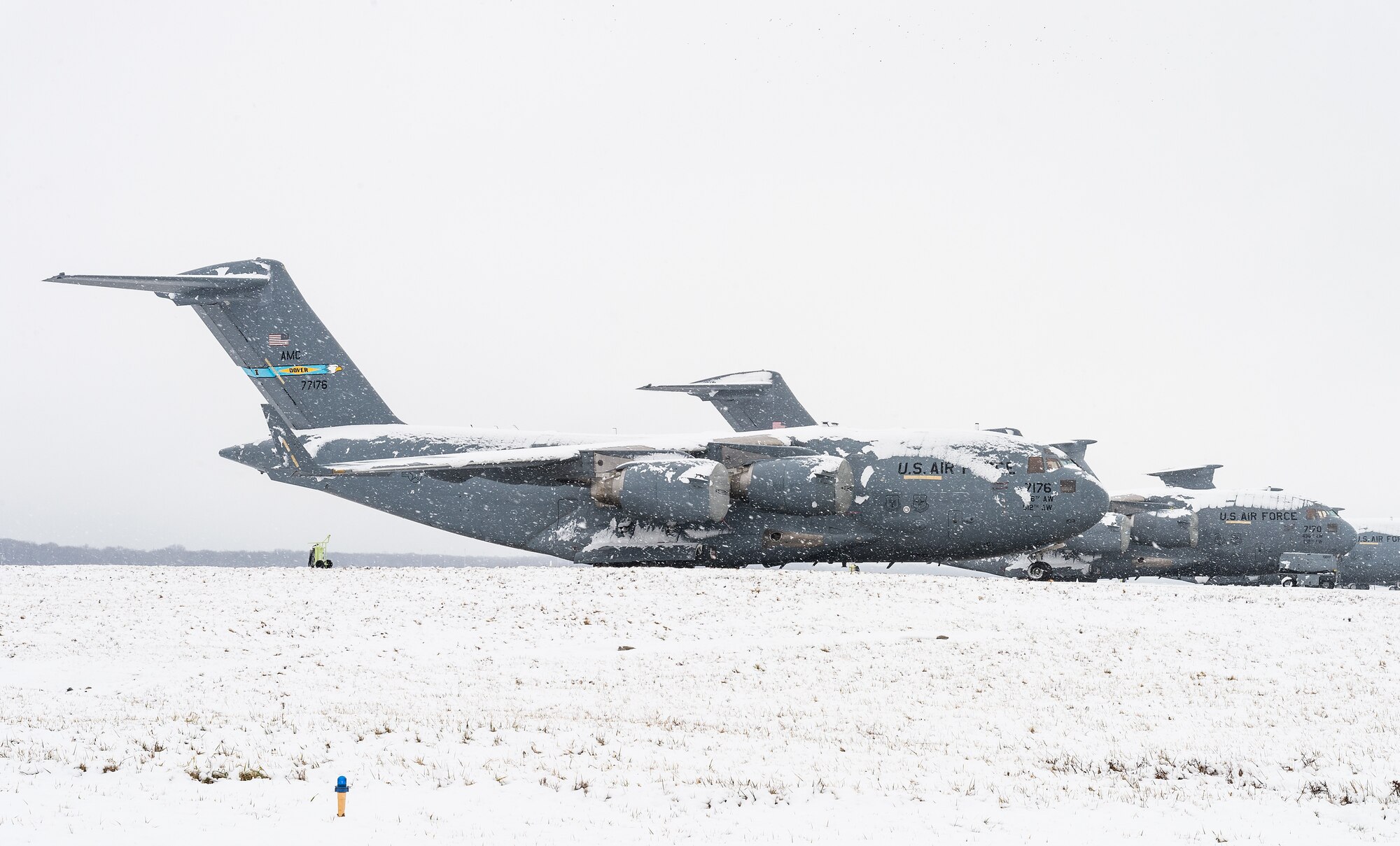 C-17 Globemaster III aircraft sit on the snow-covered flight line at Dover Air Force Base, Delaware, Feb. 7, 2021. As snow fell, the base continued normal operations and prepared for additional snowfall. (U.S. Air Force photo by Roland Balik)