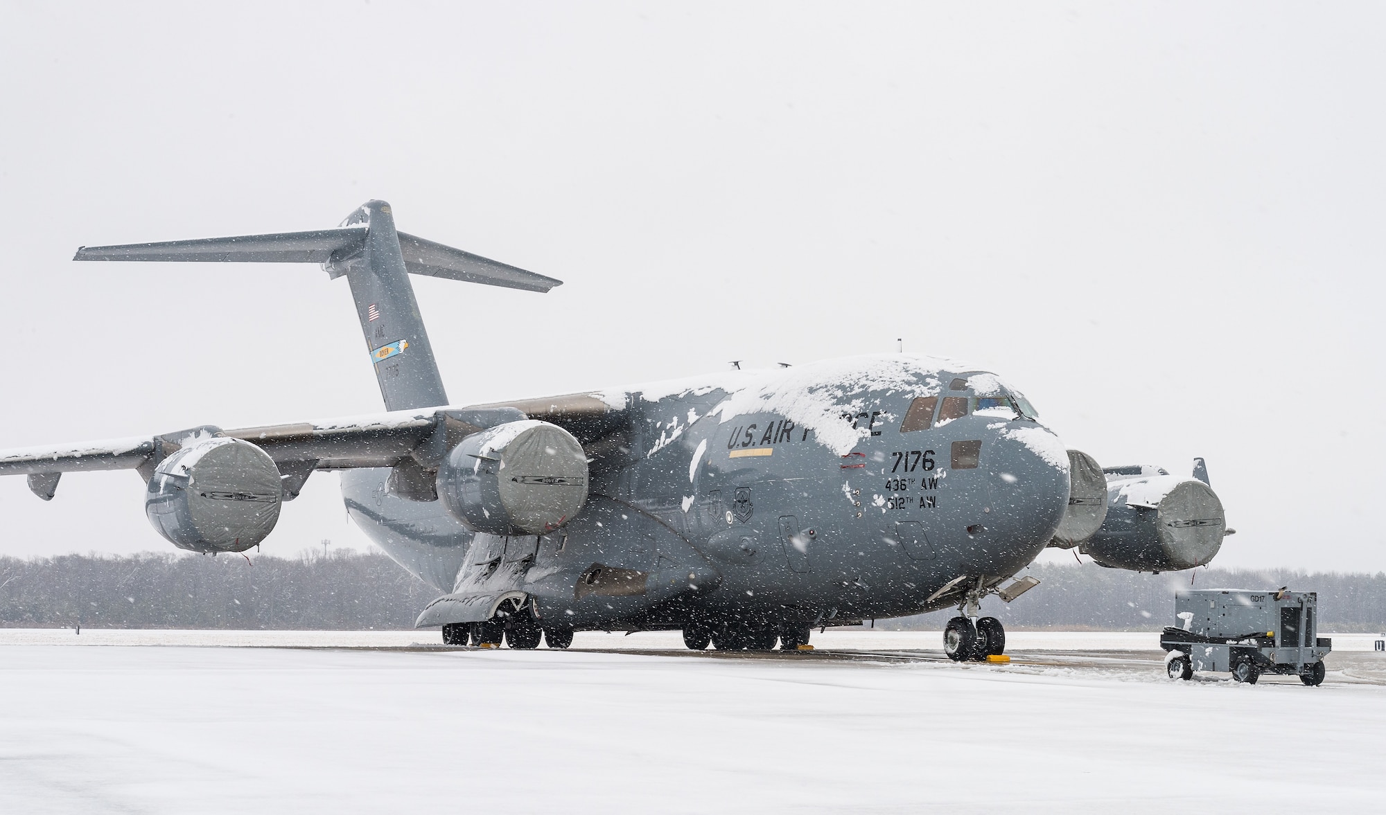 A snow-covered C-17 Globemaster III sits on the flight line at Dover Air Force Base, Delaware, Feb. 7, 2021. As snow fell, the base continued normal operations and prepared for additional snowfall. (U.S. Air Force photo by Roland Balik)