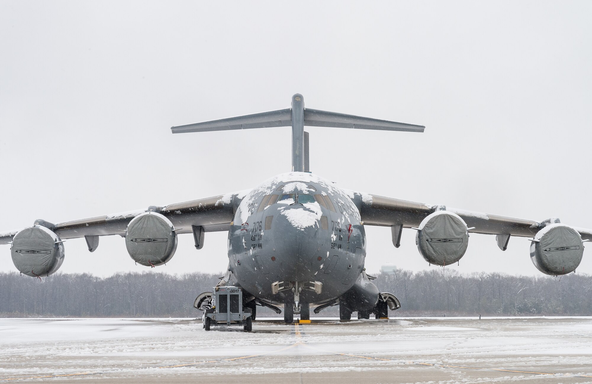 A snow-covered C-17 Globemaster III sits on the flight line at Dover Air Force Base, Delaware, Feb. 7, 2021. As snow fell, the base continued normal operations and prepared for additional snowfall. (U.S. Air Force photo by Roland Balik)