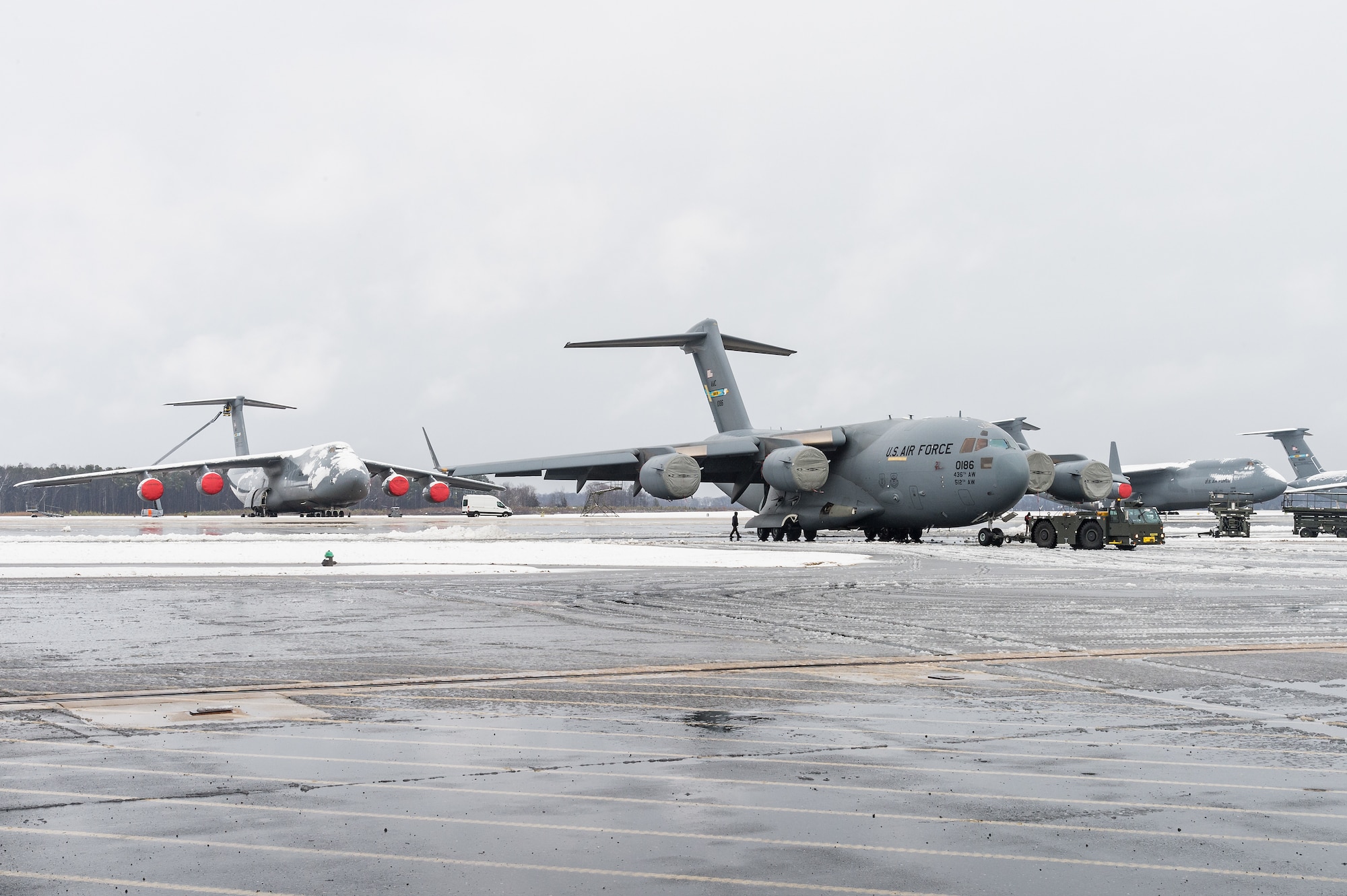 A maintenance tow team from the 736th Aircraft Maintenance Squadron, tow a C-17 Globemaster III from the flight line into a hangar to facilitate maintenance out of the weather at Dover Air Force Base, Delaware, Feb. 7, 2021. As snow fell, the base continued normal operations and prepared for additional snowfall. (U.S. Air Force photo by Roland Balik)