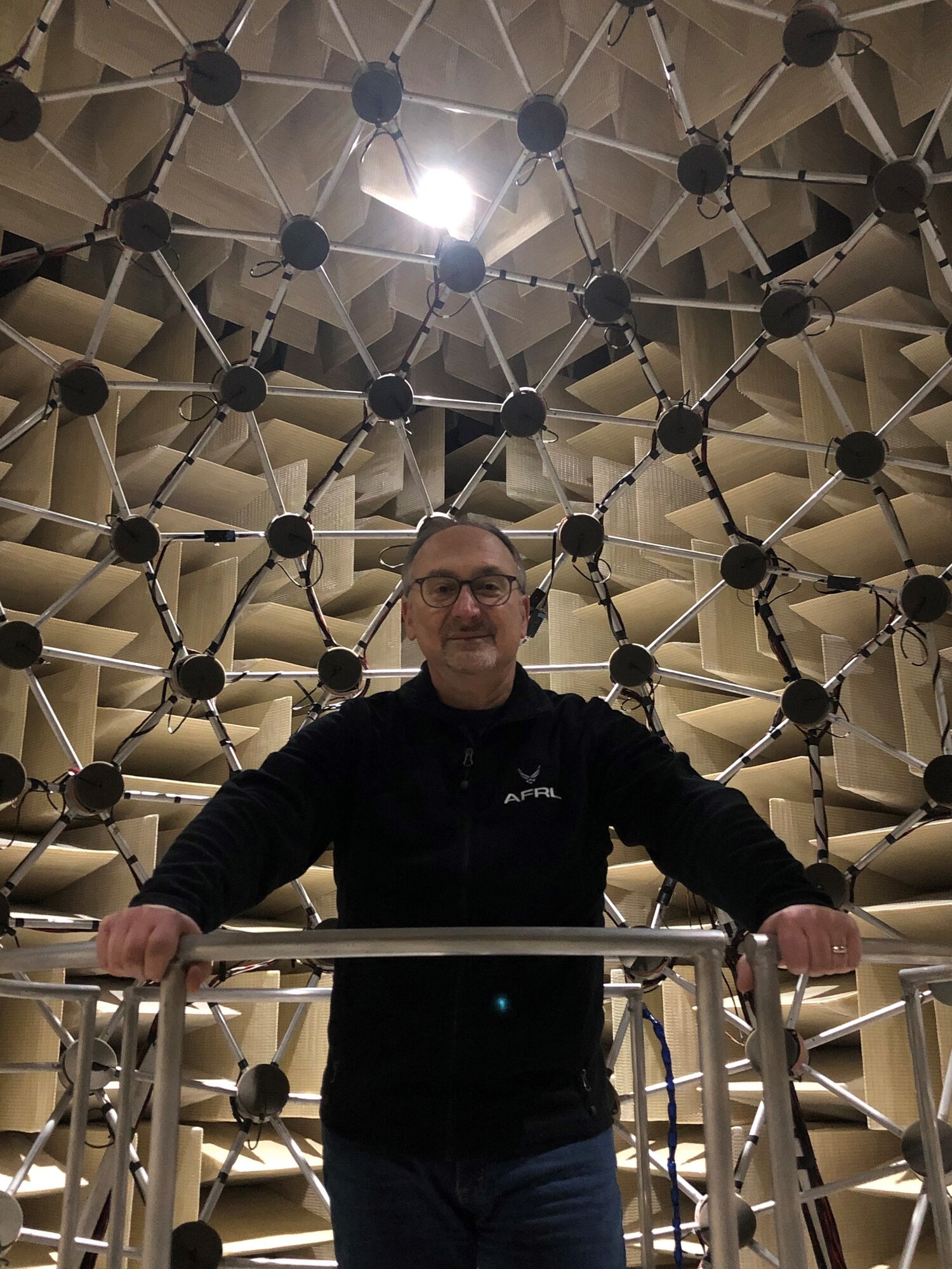 Dr. Brian Simpson, of the 711th Human Performance Wing’s Sensory Systems Branch, stands inside AFRL’s Auditory Localization Facility, an anechoic chamber that contains a 14-foot spherical array of 277 loudspeakers. The facility was designed for studying human auditory perception in complex acoustic environments. (Courtesy photo)