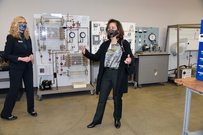 Photo shows two women looking at equipment in training room.
