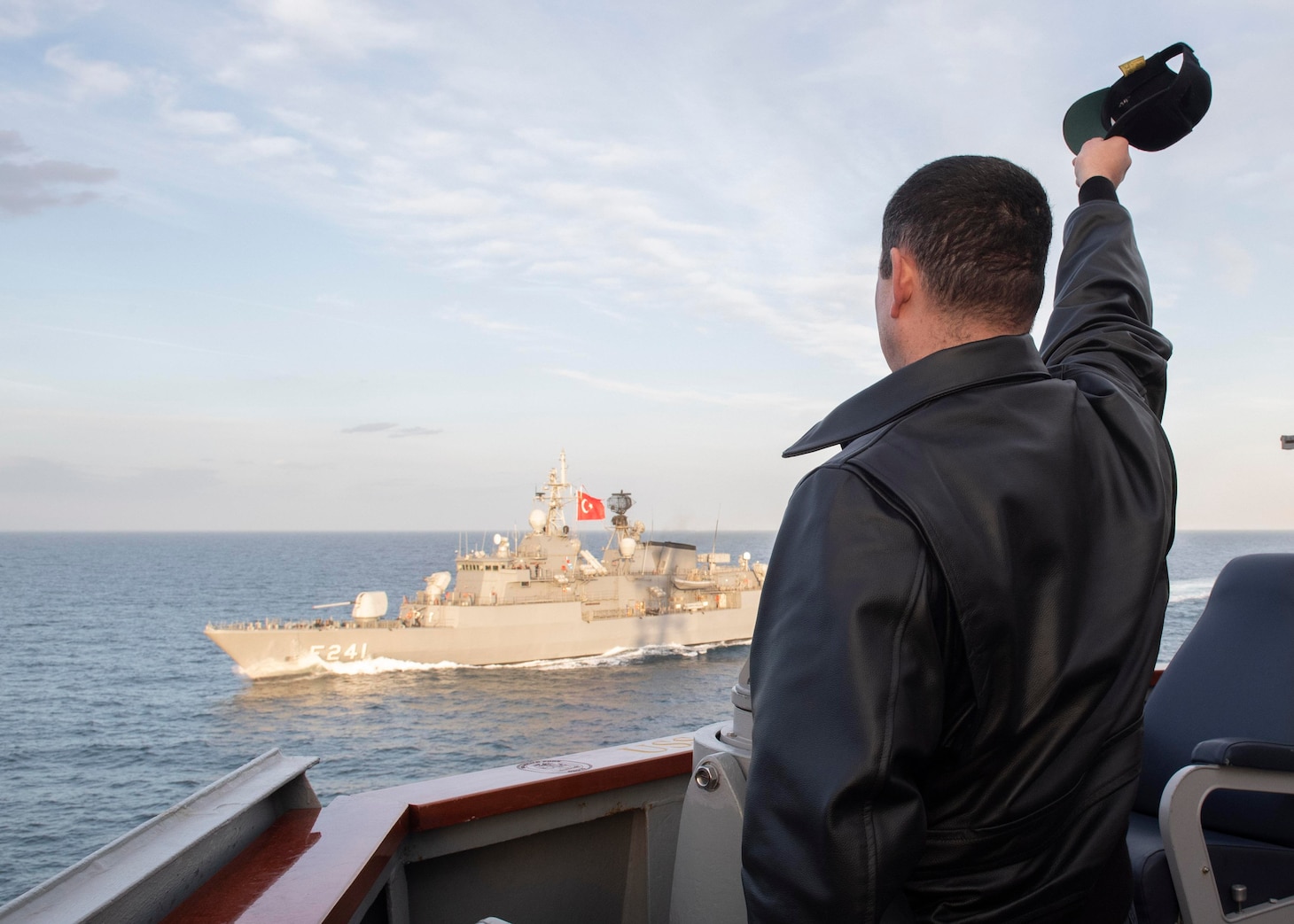 210209-N-RG171-0319 BLACK SEA (Feb. 9, 2021) Cmdr. Matthew Curnen, commanding officer of the Arleigh Burke-class guided-missile destroyer USS Donald Cook (DDG 75), waves to the Turkish navy Yavuz-class TCG Turgutreis (F-241) during a passing exercise in the Black Sea, Feb. 9, 2021. Donald Cook, forward-deployed to Rota, Spain, is on patrol in U.S. Sixth Fleet in support of regional allies and partners and U.S. national security in Europe and Africa. (U.S. Navy photo by Mass Communication Specialist 3rd Class Will Hardy/Released)