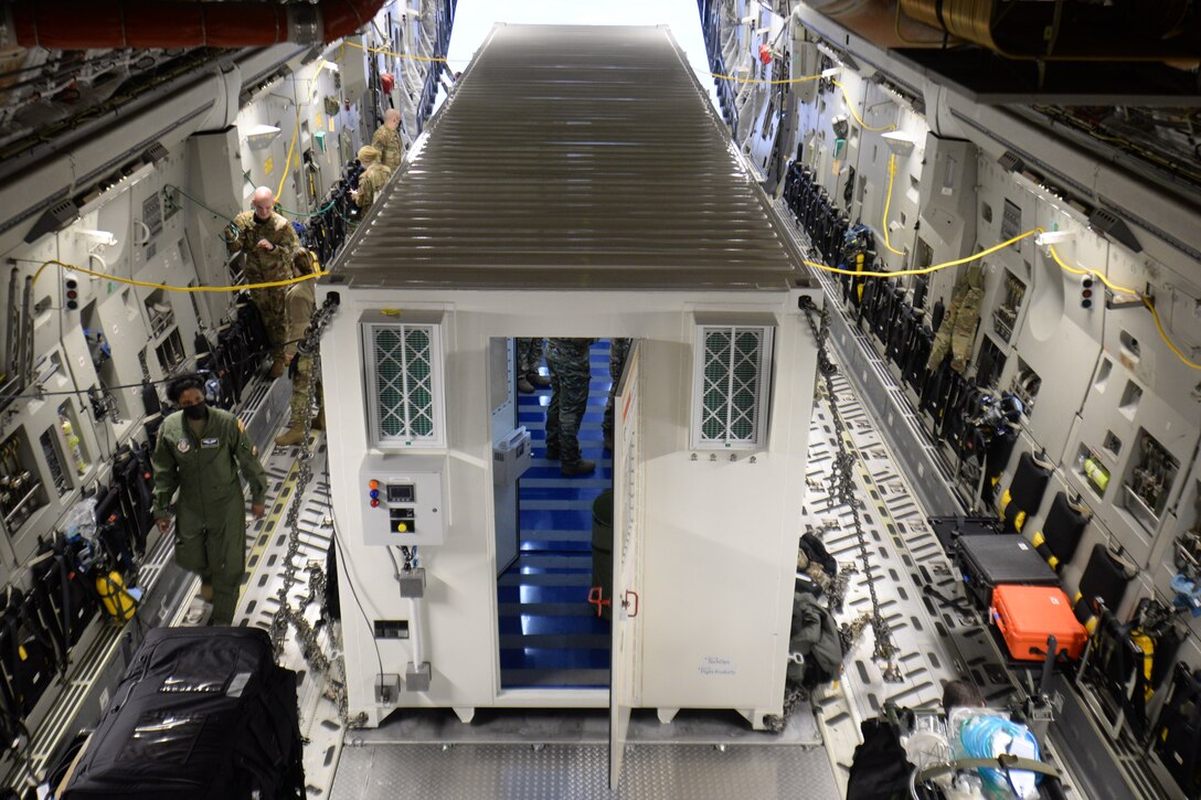 U.S. Air Force Airmen assigned to the 10th Expeditionary Aeromedical Evacuation Flight familiarize themselves with a Negatively Pressurized Conex secured inside a C-17 Globemaster III aircraft during a training at Ramstein Air Base, Germany, Jan. 30, 2021.