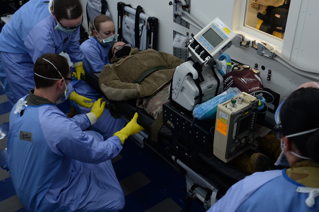 U.S. Air Force Airmen assigned to the 10th Expeditionary Aeromedical Evacuation Flight secure a litter holding a simulated patient and medical equipment inside a Negatively Pressurized Conex during training at Ramstein Air Base, Germany, Jan. 30, 2021.