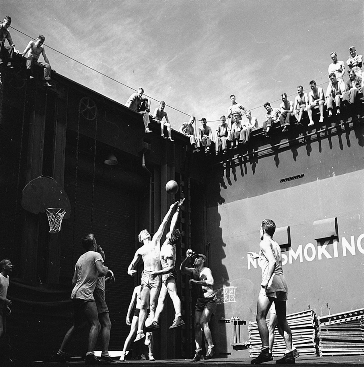Men on a ship play a game of basketball.