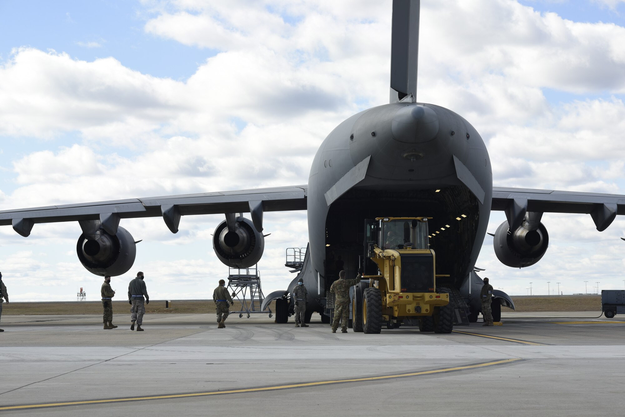 North Carolina Air National Guard members assist U.S. Air Force Air Transportation Specialist, Staff. Sgt. Jason Moore, 145th Logistics Readiness Squadron, as he loads a large item aboard a C-17 Globemaster III aircraft during a Cargo Deployment Function (CDF) exercise held at the North Carolina Air National Guard Base, Charlotte Douglas International Airport, Feb. 7, 2021. A CDF is similar to a personnel deployment line where you have a station to assemble items, check them for quality and to make sure they can safely be loaded onto an aircraft. Once the items are cleared to be loaded onto an aircraft, they reach the final phase of the CDF.