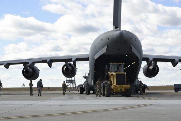 U.S. Air Force Tech. Sgt. Shaun Gamble(middle left), 156th Airlift Squadron (AS) loadmaster, provides positive feedback to Airman 1st Class Shelby Rankin, 145th AS loadmaster on the ramp of a C-17 Globemaster III aircraft during a Cargo Deployment Function (CDF) exercise held at the North Carolina Air National Guard Base, Charlotte Douglas International Airport, Feb. 7, 2021. A CDF is similar to a personnel deployment line where you have a station to assemble items, check them for quality and to make sure they can safely be loaded onto an aircraft. Once the items are cleared to be loaded onto an aircraft, they reach the final phase of the CDF.