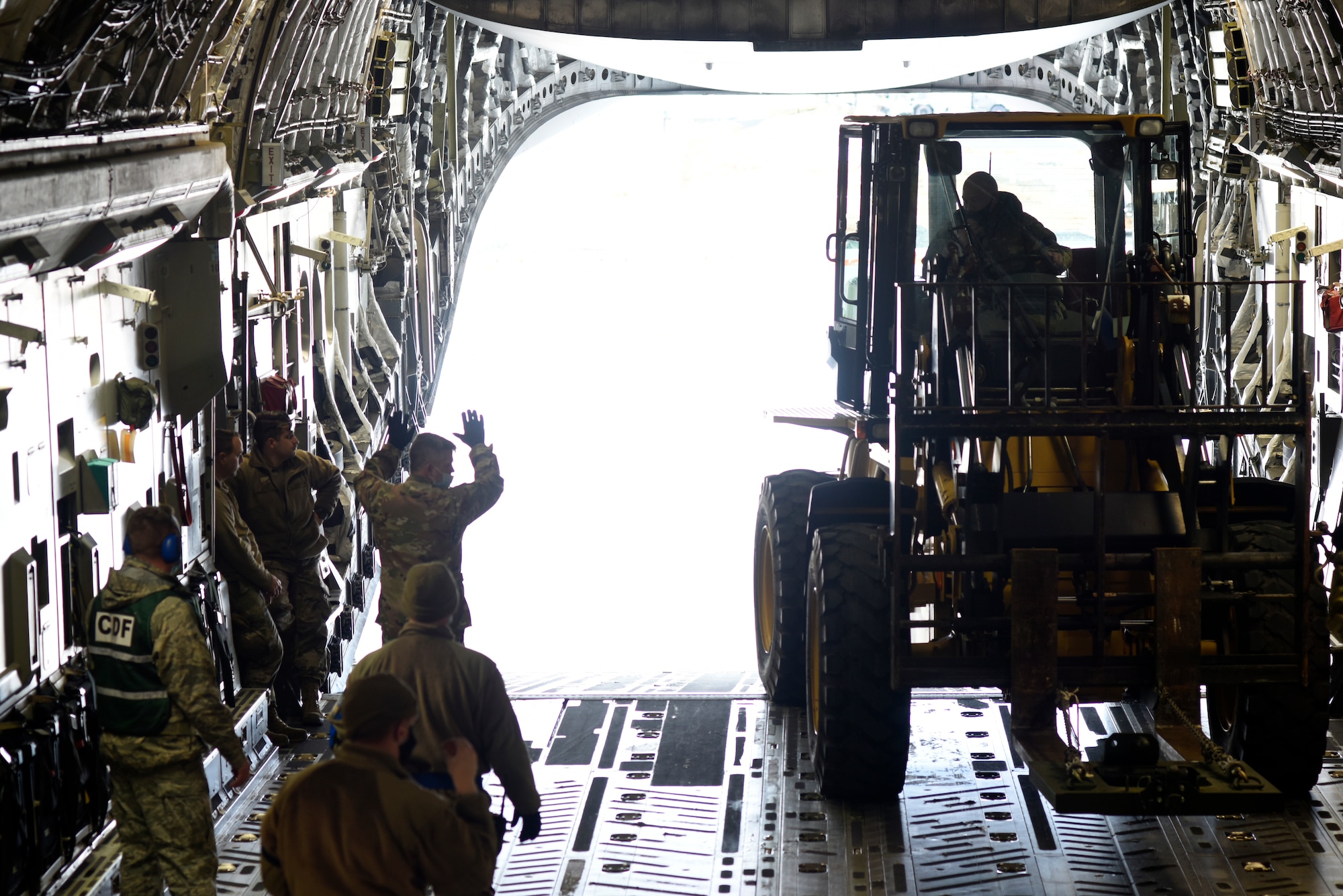 U.S. Air Force Tech. Sgt. Shaun Gamble(middle left), 156th Airlift Squadron (AS) loadmaster, provides positive feedback to Airman 1st Class Shelby Rankin, 145th AS loadmaster on the ramp of a C-17 Globemaster III aircraft during a Cargo Deployment Function (CDF) exercise held at the North Carolina Air National Guard Base, Charlotte Douglas International Airport, Feb. 7, 2021. A CDF is similar to a personnel deployment line where you have a station to assemble items, check them for quality and to make sure they can safely be loaded onto an aircraft. Once the items are cleared to be loaded onto an aircraft, they reach the final phase of the CDF.