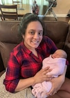 Personnel Specialist Chief Veronica Guadalupe Foley poses for a photo while holding her newborn daughter.
