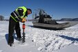 Man drills hole in ice