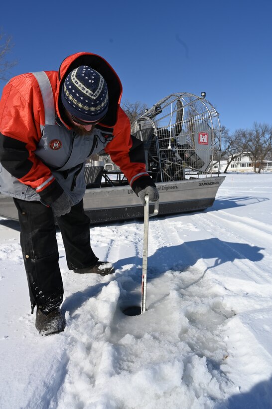 Man measures ice thickness