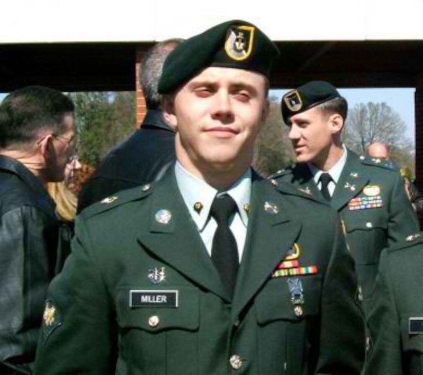 A man in uniform and cap looks at the camera.