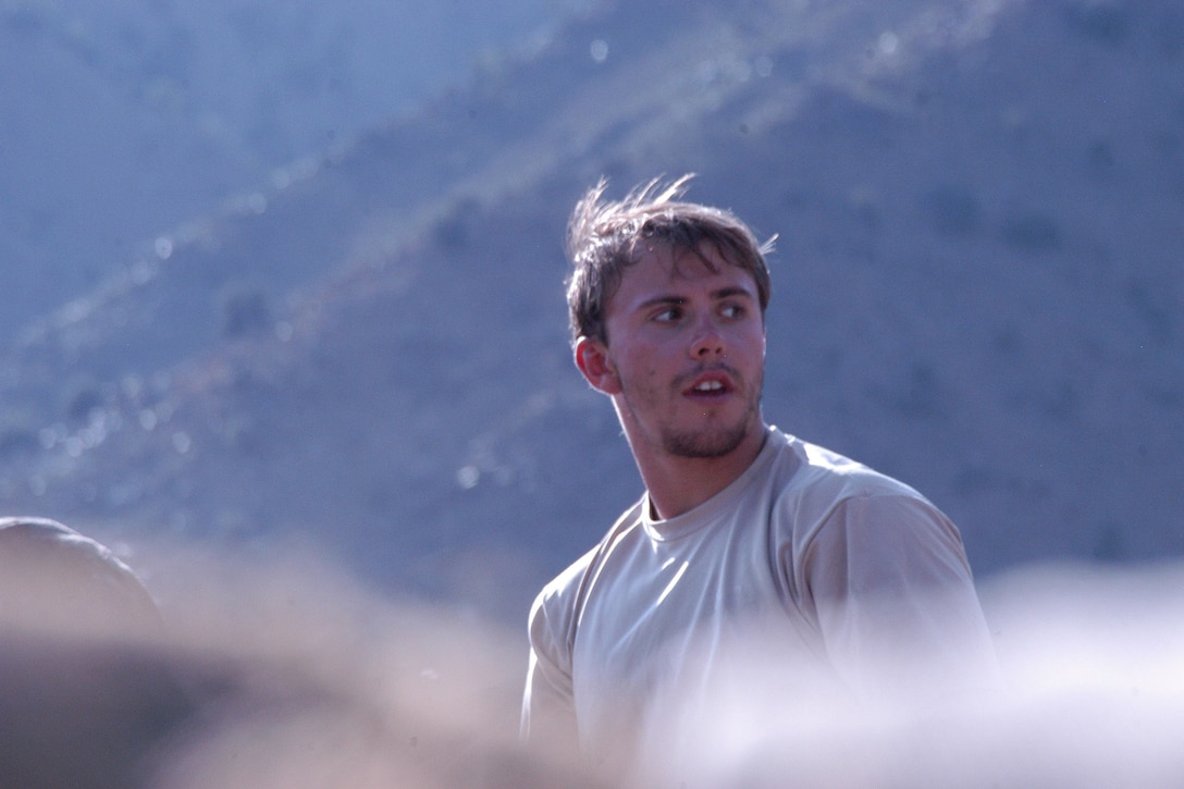 A man looks to the side as the wind sweeps his hair.