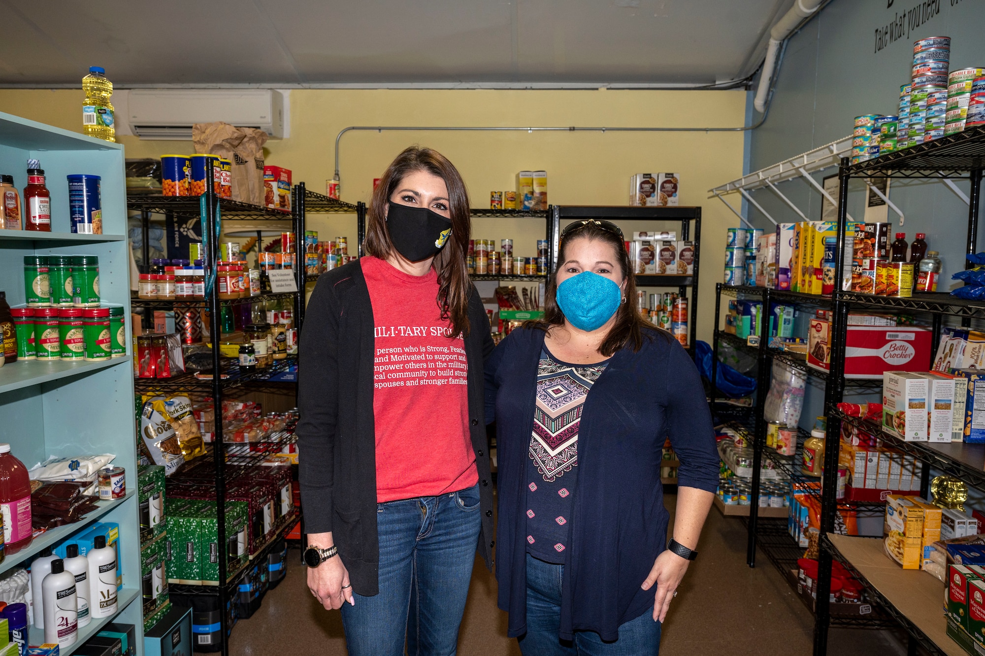 Lynne Otis, 436th Wing Staff Agency key spouse, and Jessica Hammer, 436th Aircraft Maintenance Squadron key spouse, pose for a photo in the newly established food pantry at Dover Air Force Base, Delaware, Jan. 20, 2021. Located in the Airman’s Attic, the food pantry was created by Otis and Hammer in an effort to alleviate financial burdens Airmen and their families may face during the COVID-19 pandemic. (U.S. Air Force photo by Airman 1st Class Cydney Lee)