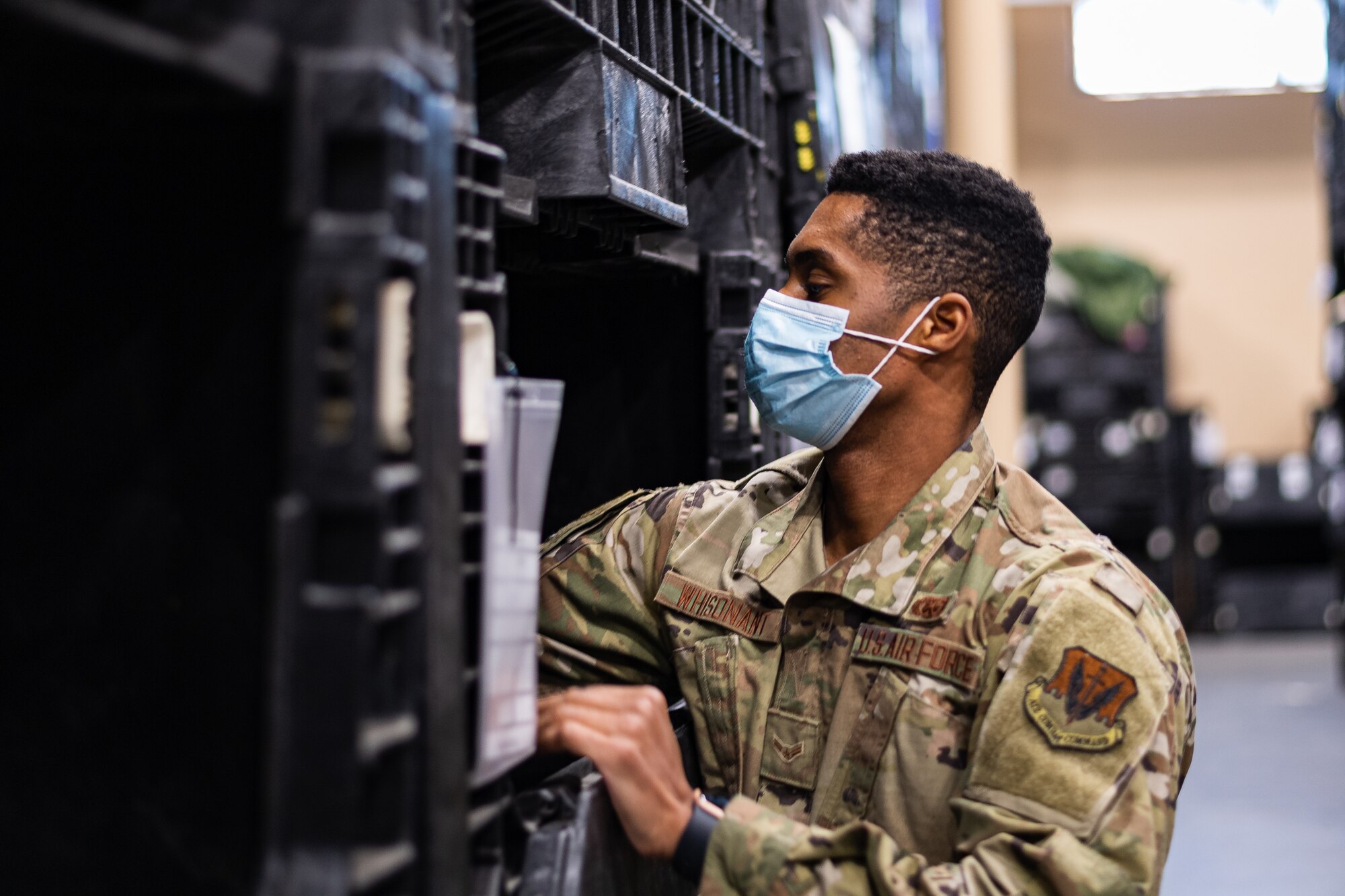 A photo of an Airman grabbing gear from a bin.