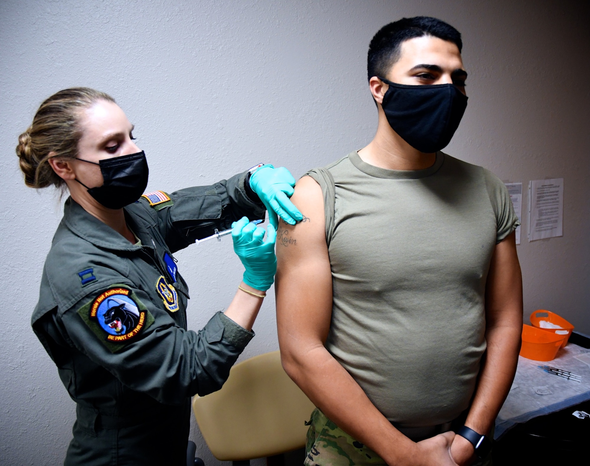 Senior Airman Warren McKeithen, 932nd Airlift Wing Medical Squadron health services administrator, receives a COVID-19 vaccine shot from Capt. Jessica Walser, a 932nd MDS critical care air transport nurse, at the 375th Medical Group Clinic, Scott Air Force Base, Ill., on Feb. 9, 2021. The vaccines were recently approved by the Food and Drug Administration under an emergency use authorization, and are currently offered to DoD personnel on a voluntary basis.  They are distributed using the Department of Defense’s phased approach. McKeithen noted, "if medical gets called out to assist with someone that's COVID positive the shot definitely helps protect us in the long run."  McKeithen handles a multitude of duties including orders and readiness related areas in the Air Force Reserve medical unit.  (U.S. Air Force photo by Lt. Col. Stan Paregien)