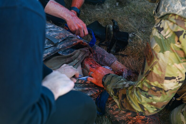 Medics access a wound on manikin and demonstrate life-saving techniques to stop the bleeding during the 2021 Tactical Combat Casualty Care exercise on Buckley Air Force Base, Colo., Feb. 4, 2021.