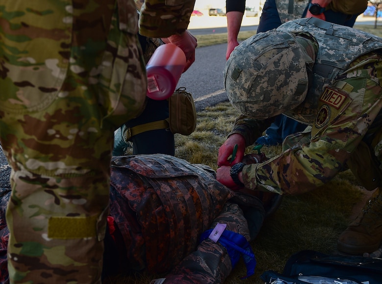 A medic participating in the 2021 Tactical Combat Casualty Care exercise creates an incision in the neck of a medical manikin to open its airway on Buckley Air Force Base, Colo., Feb. 4, 2021.