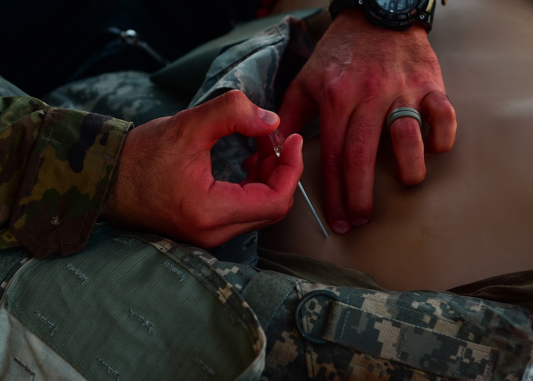 A medic participating in the 2021 Tactical Combat Casualty Care exercise treats a medical manikin with air in the chest cavity using needle decompression on Buckley Air Force Base, Colo., Feb. 4, 2021.