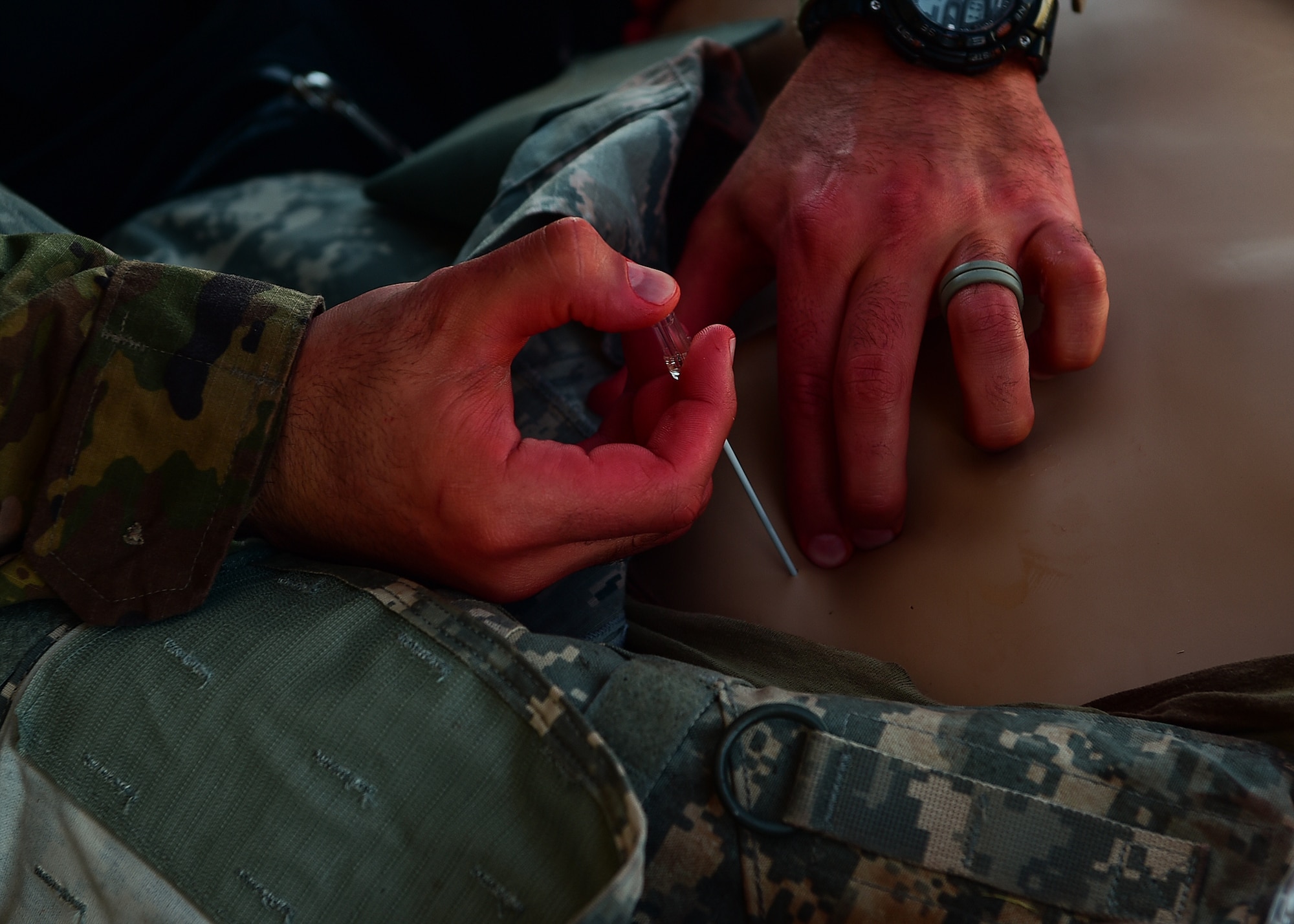A medic participating in the 2021 Tactical Combat Casualty Care exercise treats a medical manikin with air in the chest cavity using needle decompression on Buckley Air Force Base, Colo., Feb. 4, 2021.