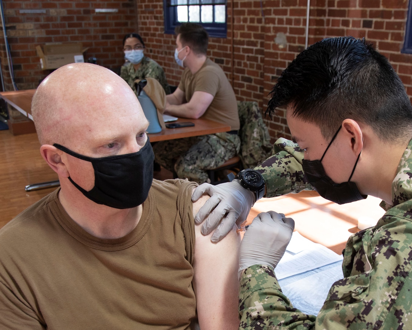 Capt. Jip Mosman, commander, Puget Sound Naval Shipyard & Intermediate Maintenance Facility, receives the COVID-19 vaccination Feb. 10, 2021, in the former Sam Adams Brewhouse on Naval Base Kitsap-Bremerton. Approximately 200 PSNS & IMF personnel received the first-of-two Moderna COVID-19 vaccine shots in what is expected to be a phased employee vaccination process.