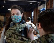 Anna Taylor, deputy public affairs officer, at Puget Sound Naval Shipyard & Intermediate Maintenance Facility, receives the COVID-19 vaccination Feb. 10, 2021, in the former Sam Adams Brewhouse on Naval Base Kitsap-Bremerton. Approximately 200 PSNS & IMF personnel received the first-of-two Moderna COVID-19 vaccine shots in what is expected to be a phased employee vaccination process.