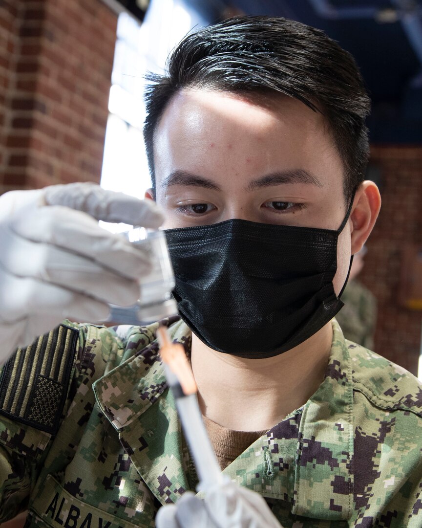 Petty Officer 3rd Class Kenneth Abayalde, with Naval Hospital Bremerton, prepares a COVID-19 vaccine shot Feb. 10, 2021, in the former Sam Adams Brewhouse on Naval Base Kitsap-Bremerton. Approximately 200 Puget Sound Naval Shipyard & Intermediate Maintenance Facility personnel received the first-of-two Moderna COVID-19 vaccine shots Feb. 10, 2021, in what is expected to be a phased employee vaccination process.