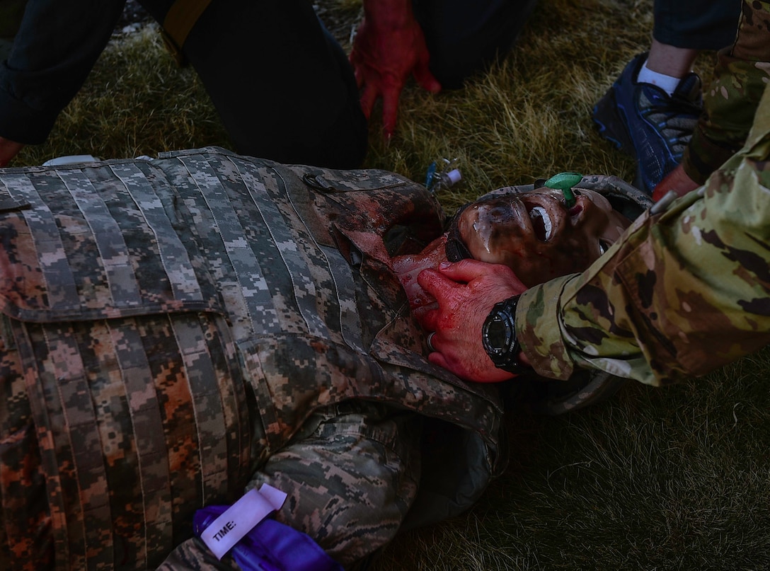 Medics perform a cricothyroidotomy to open the airway of a medical manikin experiencing inhalation burns during the Tactical Combat Casualty Care exercise on Buckley Air Force Base, Colo., Feb. 4, 2021.