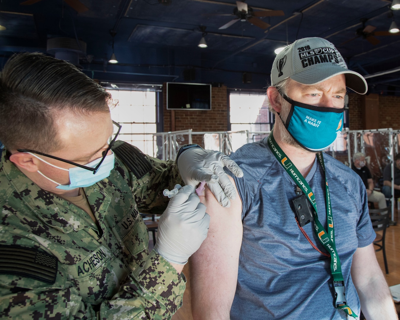 Brian Russell, with Code 105.3, Radiological Monitoring Division, at Puget Sound Naval Shipyard & Intermediate Maintenance Facility, receives the COVID-19 vaccination Feb. 10, 2021, in the former Sam Adams Brewhouse on Naval Base Kitsap-Bremerton. Approximately 200 PSNS & IMF personnel received the first-of-two Moderna COVID-19 vaccine shots in what is expected to be a phased employee vaccination process.