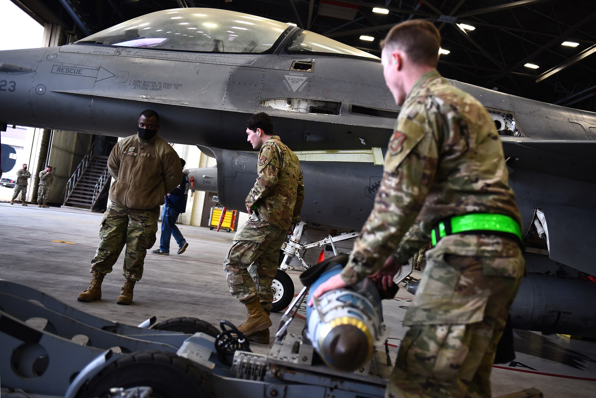 Senior Airman Merlin Reiland, 8th Maintenance Squadron load crew team member, and Staff Sgt. Brian Thompson, 8th MXS load crew team chief, prepare to transport munitions during the Annual Load Crew Competition at Kunsan Air Base, Republic of Korea, Feb. 6, 2021. Three teams completed in four categories to include dress and appearance, a weapons knowledge test, a toolbox inspection and a weapons load. (U.S. Air Force photo by Senior Airman Suzie Plotnikov)
