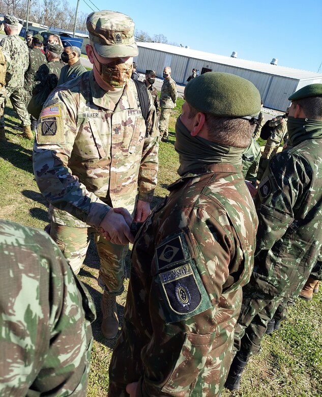 Command Sgt. Maj. Trevor Walker, Army South command sergeant major, greets a paratrooper from the Brazilian Airborne Company at the Joint Readiness Training Center at Fort Polk, Louisiana, Feb. 1. The participation of the Brazilian Airborne Company is the largest deployment by any South American partner nation army in the Western Hemisphere to train alongside U.S. forces at JRTC.