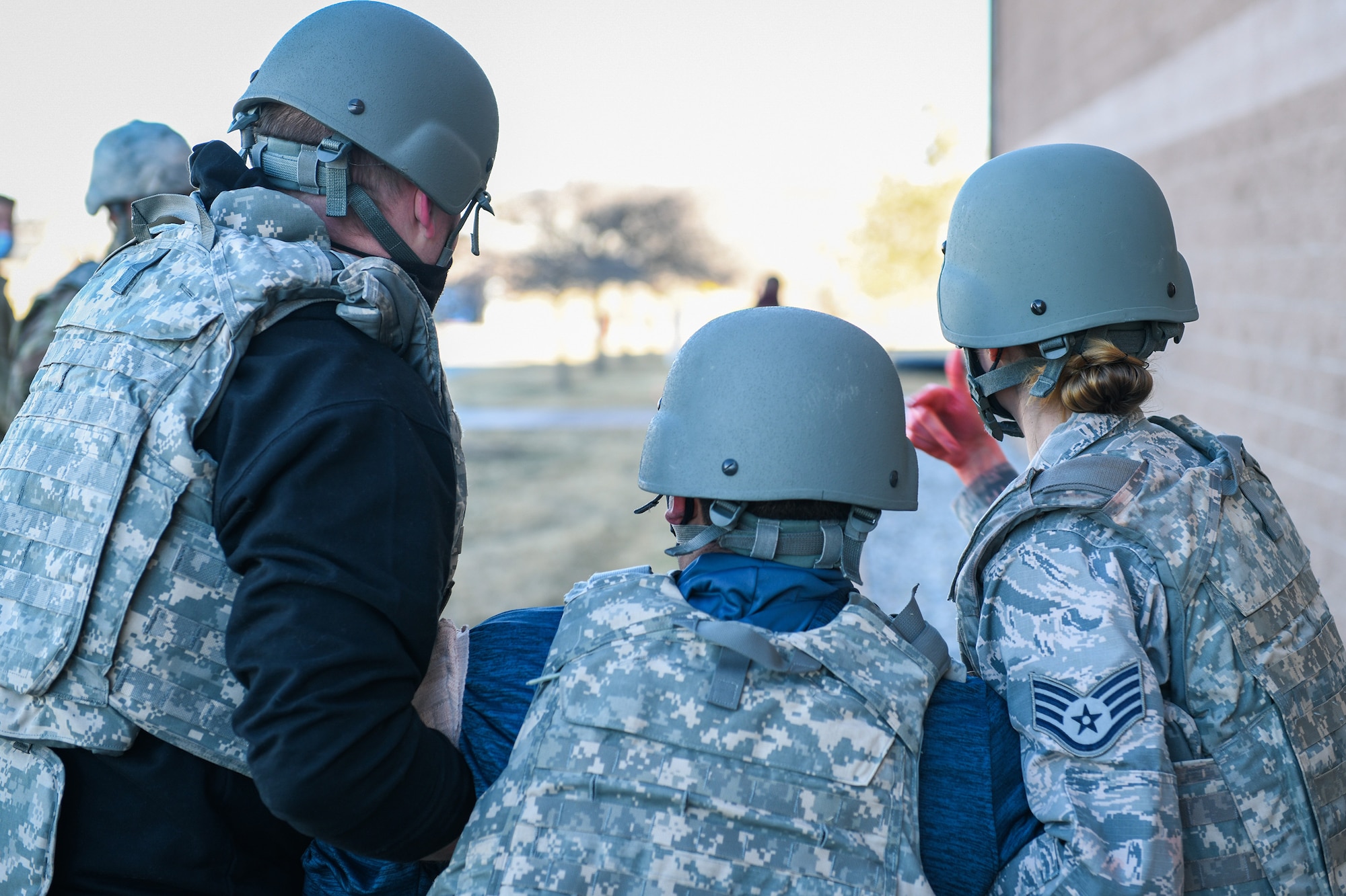 Staff Sgt. William Shimel (left), a 140th Air National Guard Medical Group aerospace medical technician, and Staff Sgt. Camille Dysart (right), a 140th ANG MDG CBRNE enhanced response force package medicine technician, transport Airman 1st Class Justin Rosales, a 460th Security Forces Squadron restricted area entry controller, to a safer location during an exercise to train the medics' response capabilities on Buckley Air Force Base, Colo., Feb. 4, 2021.