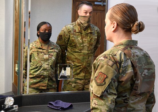 Airman looking into the mirror sees reflection of future Airmen.