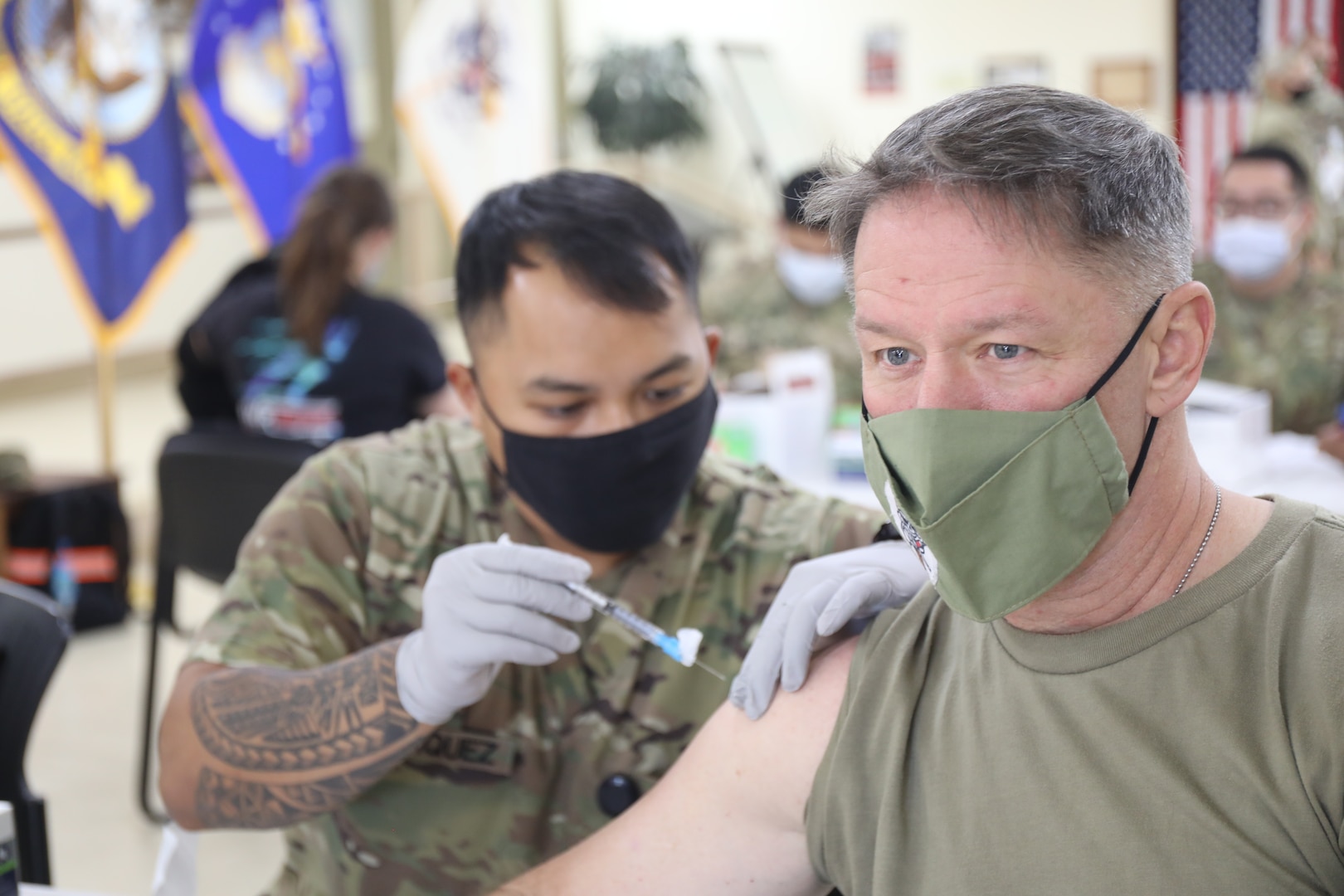 Spc. Vincebryan Marquez, healthcare specialist, 228th Combat Support Hospital, administers the Moderna COVID-19 vaccine to Lt. Col. Scott Gadberry, anesthesiologist, 228th Combat Support Hospital, at Camp Arifjan, Kuwait, Jan. 18, 2021. Camp Arifjan is utilizing a phased distribution of the vaccine, as specified by the Department of Defense, beginning with medical personnel and first responders.