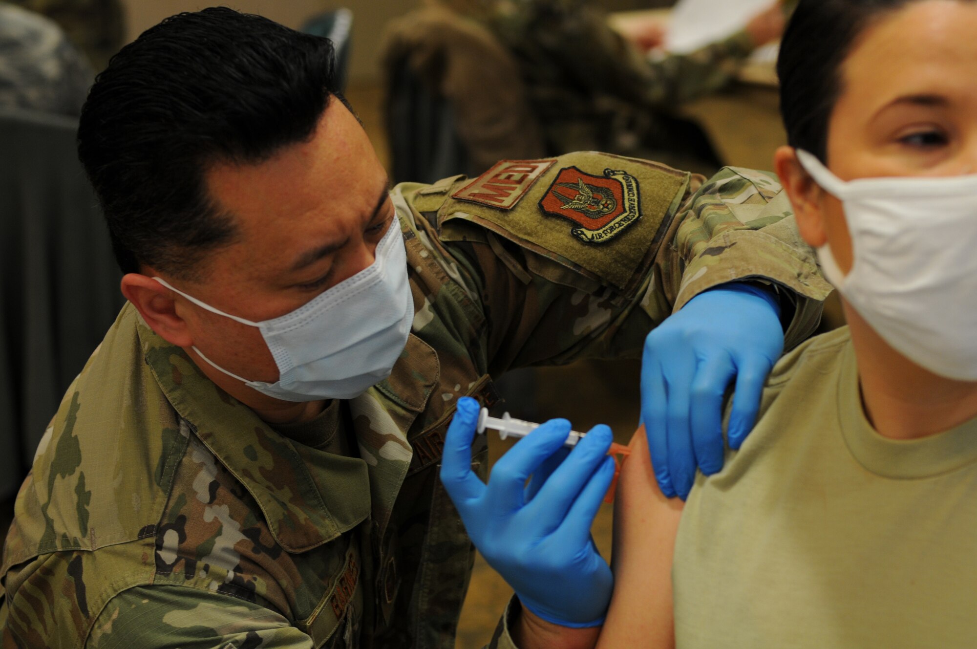 U.S. Air Force Reservist Master Sgt. John Barnes, a medical technician with the 446th Aeromedical Staging Squadron, administers the first dose of the Moderna COVID-19 vaccine to U.S. Air Force Reservist Tech. Sgt. Alexis Righero, an equal opportunity advisor with the 446th Airlift Wing, at Joint Base Lewis-McChord, Washington, Feb. 6, 2021